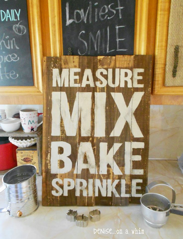 a wooden sign that says measure mix bake sprinkles on the counter