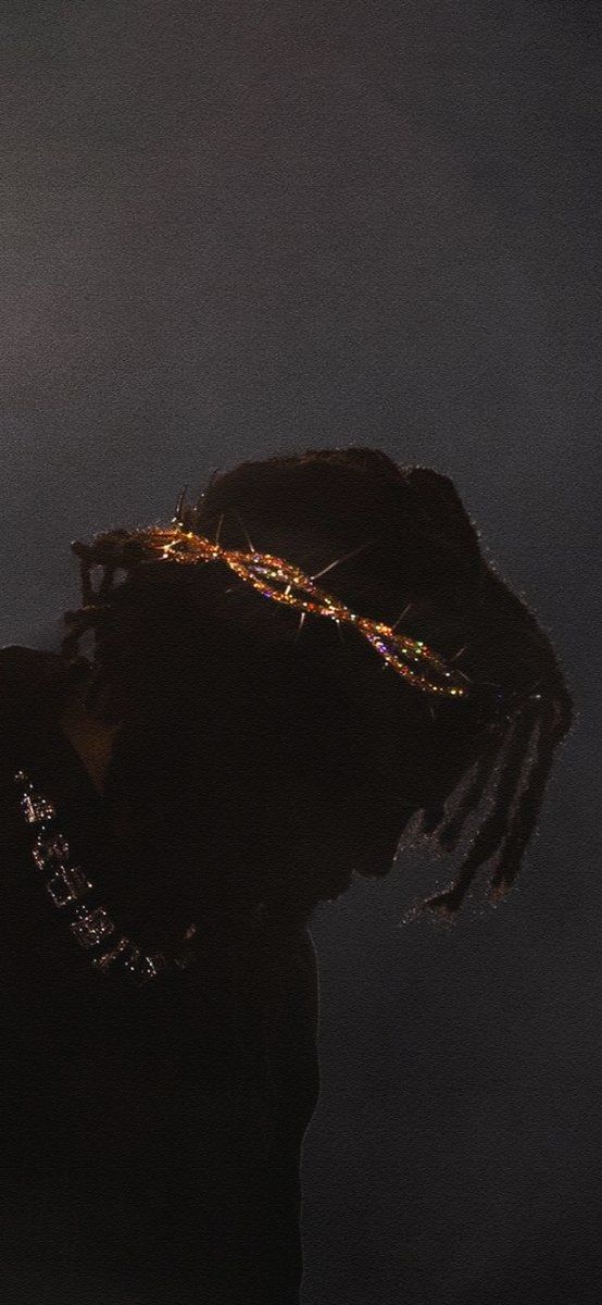 a man with dreadlocks standing in the dark