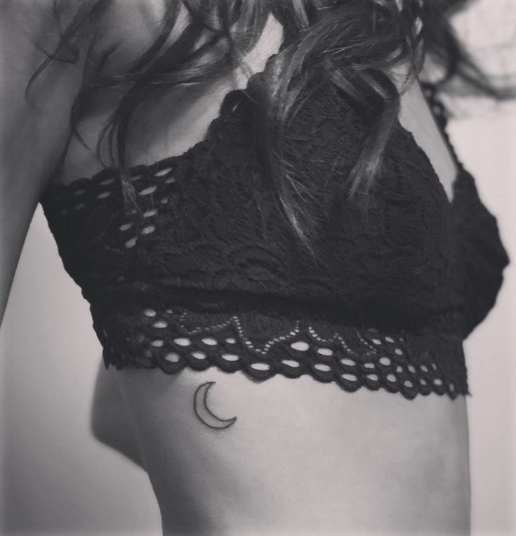 black and white photograph of a woman's stomach with the moon tattoo on her left side