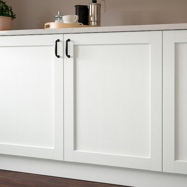 a kitchen with white cabinets and black counter tops