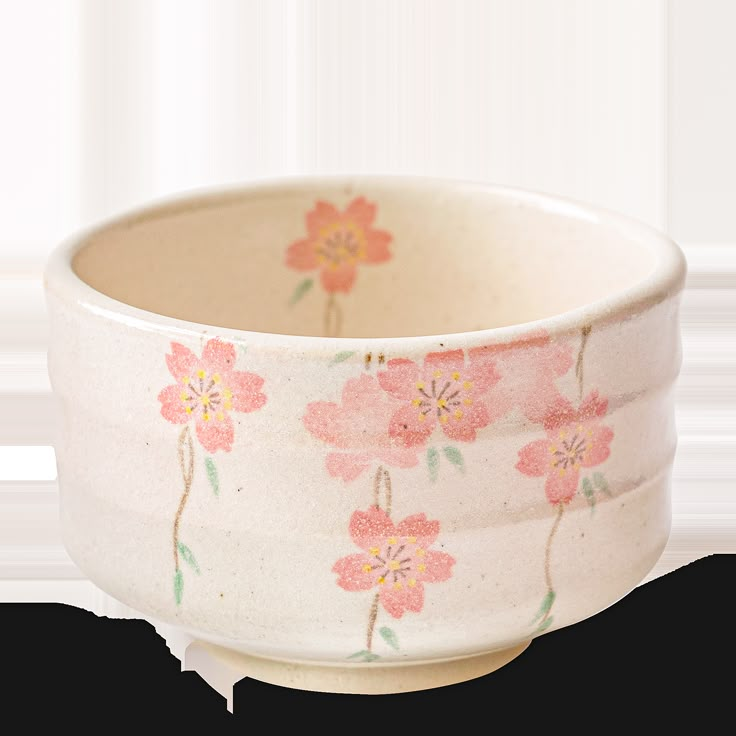 a white bowl with pink flowers painted on the outside and inside, sitting in front of a white background