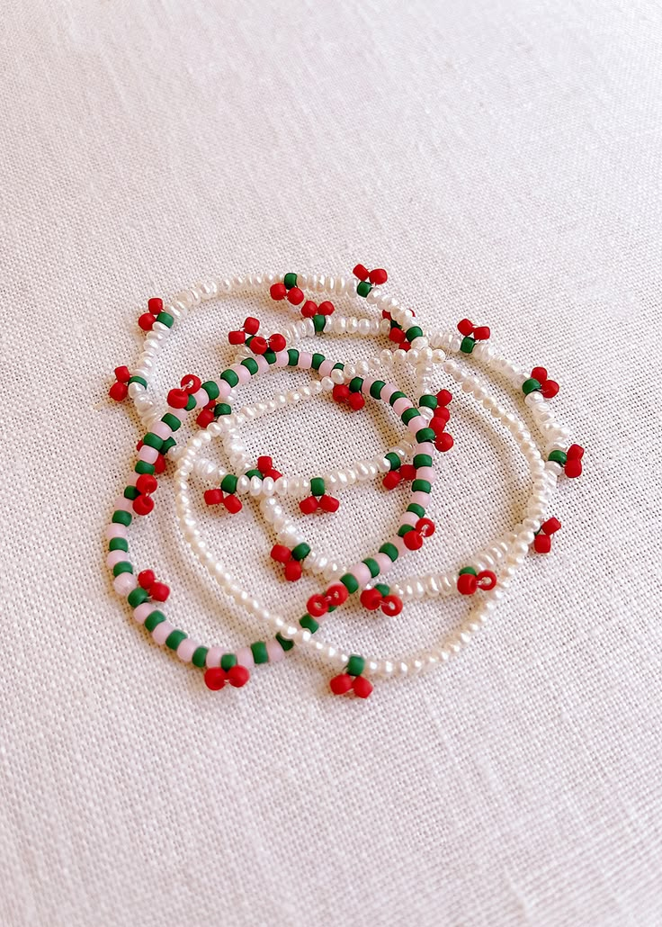 the beaded necklace has red, green and white beads on it's sides