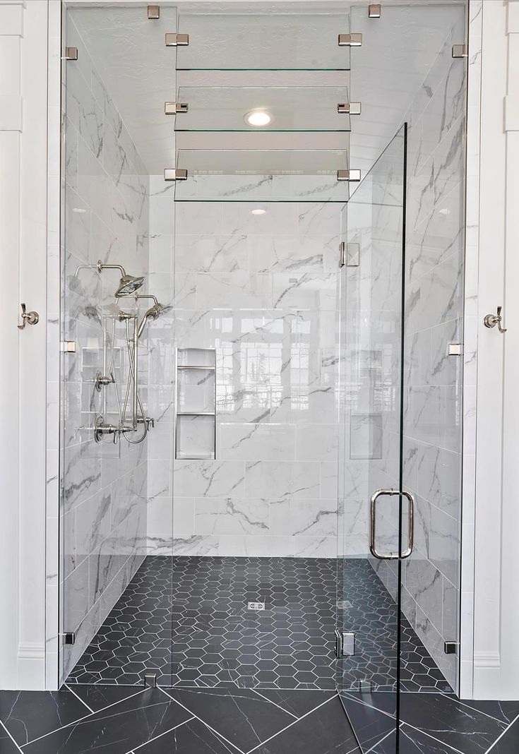 a walk in shower sitting inside of a bathroom next to a tiled floor and walls