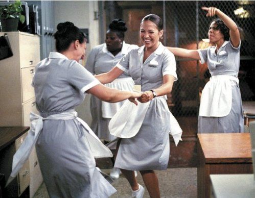 the women are dancing together in the kitchen