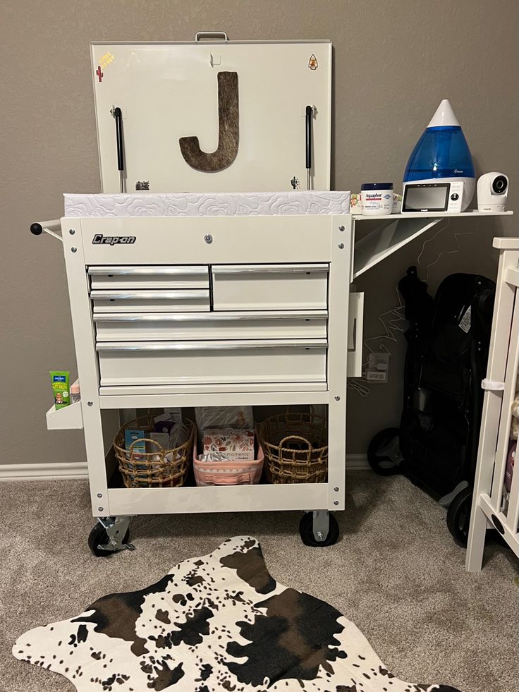 a white and black rug sitting on top of a floor next to a wooden cabinet