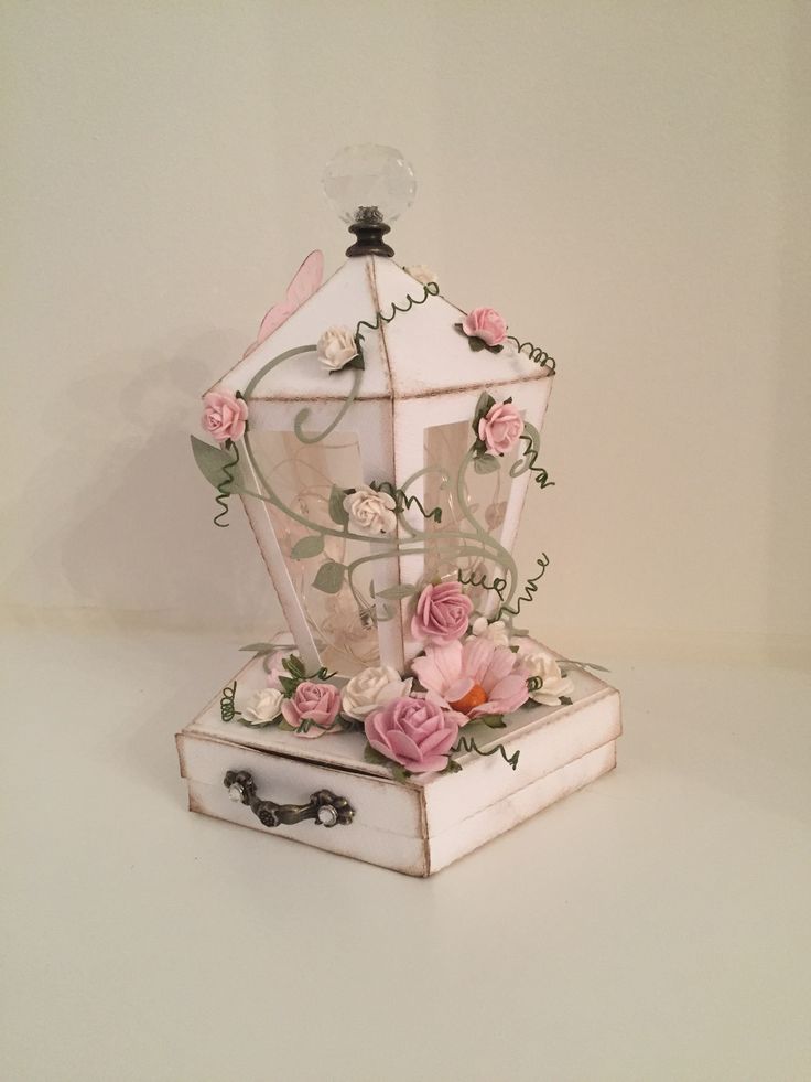 a white box with pink flowers on it and a birdcage in the middle