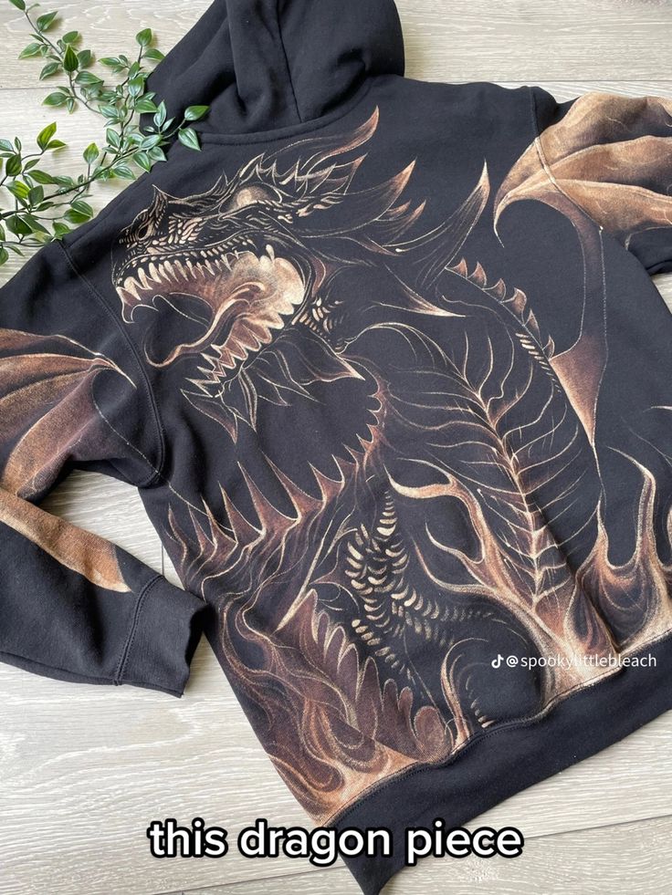 a black hoodie with an image of a dragon on it