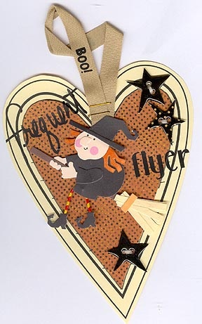 a heart shaped ornament with a witch on it