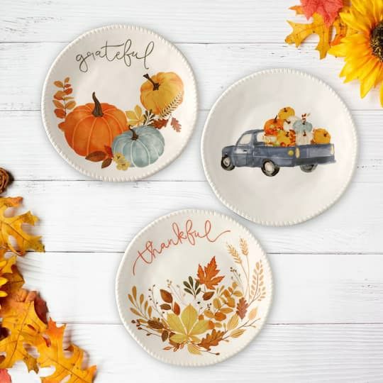 three plates decorated with fall leaves and pumpkins