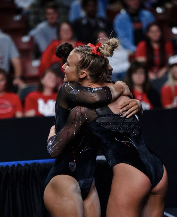 two women hugging each other in front of an audience