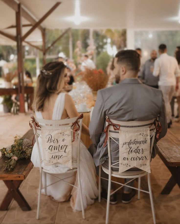 a man and woman sitting at a table in front of each other with signs on them