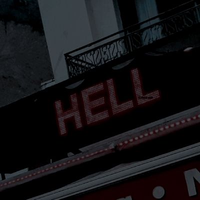 there is a sign that says hell on the side of a building in front of it