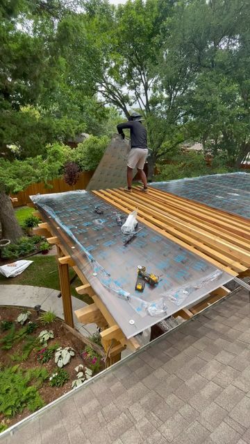 a man is working on the roof of a house