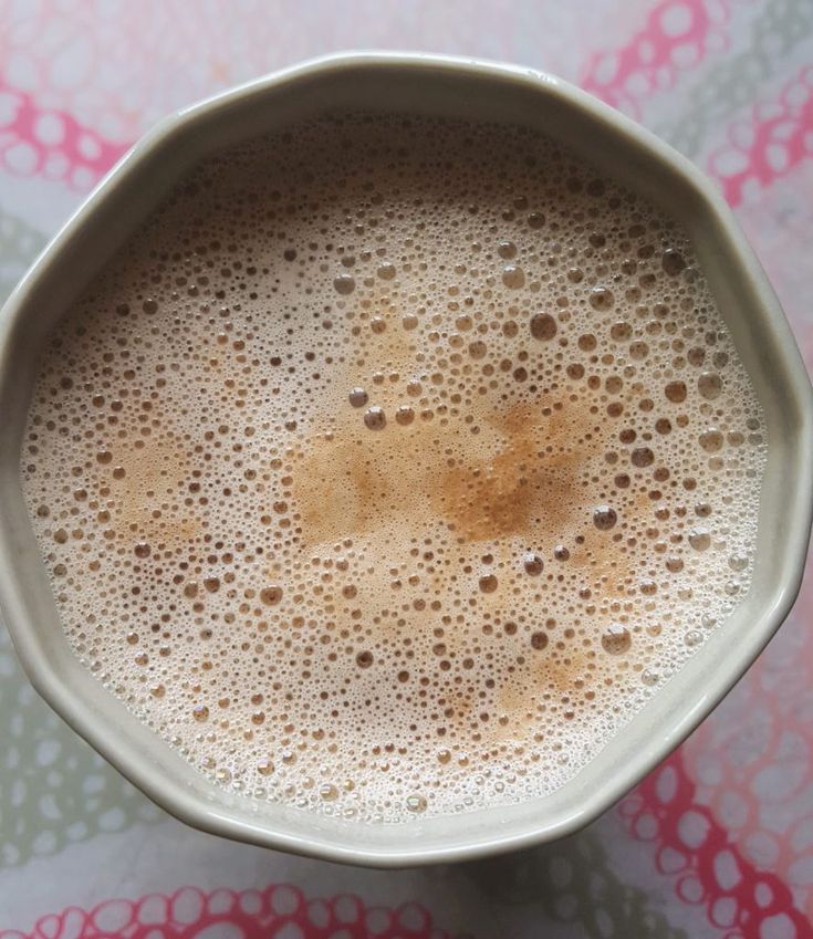 a white cup filled with liquid on top of a table