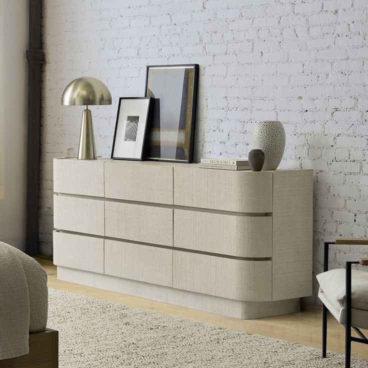 a bed room with a neatly made bed and a white brick wall