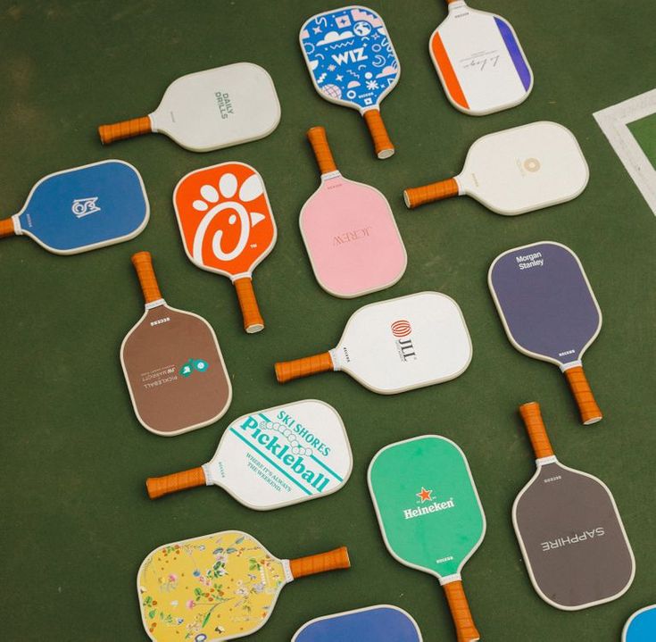 many different paddles are laid out on the table with stickers attached to them