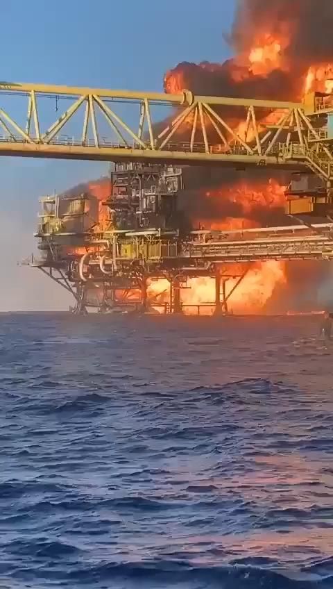 an oil rig on fire in the middle of the ocean