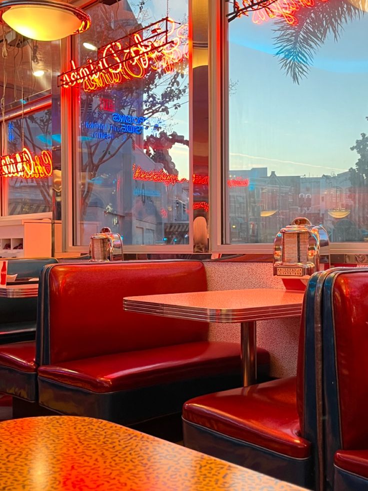 the inside of a restaurant with red booths