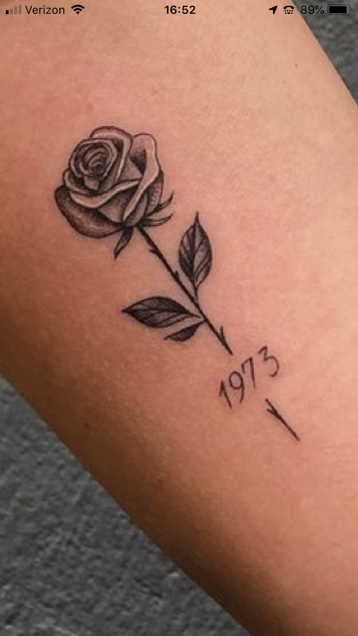 a small rose tattoo on the arm