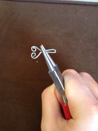 a person holding a pair of scissors in their left hand and writing on the paper