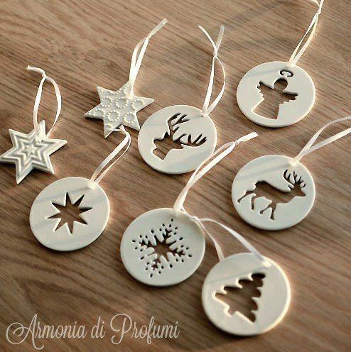 christmas ornaments are hanging from strings on a wooden table with other decorations in the shape of snowflakes