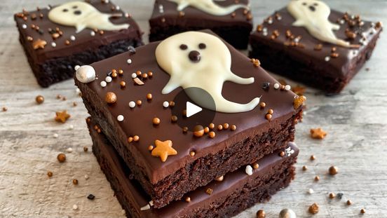 four brownies with white frosting and sprinkles on them are arranged in the shape of ghosts