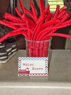 a vase filled with red straws on top of a table