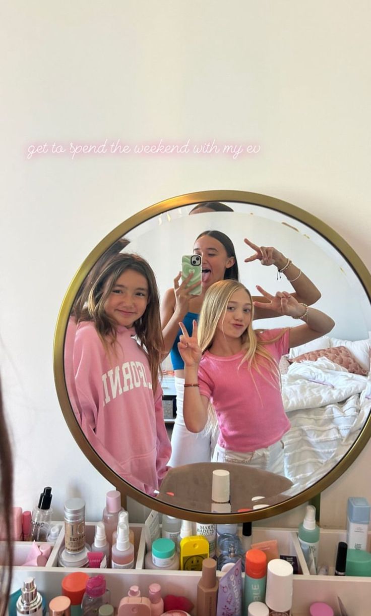 two girls in front of a mirror brushing their teeth