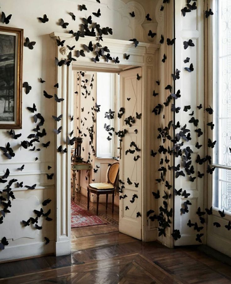 a room filled with lots of black bats flying through the air