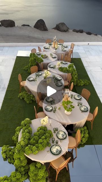 an outdoor dining area with tables and chairs set up for a formal dinner by the water