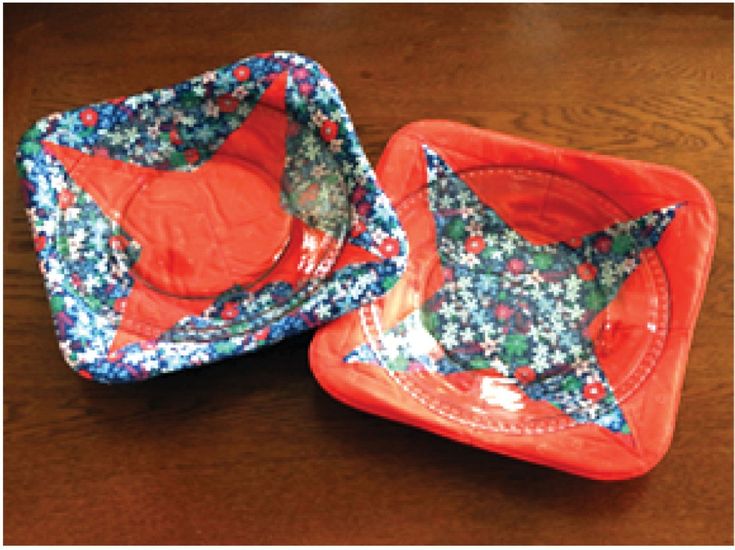 two red and blue dishes sitting on top of a wooden table next to each other