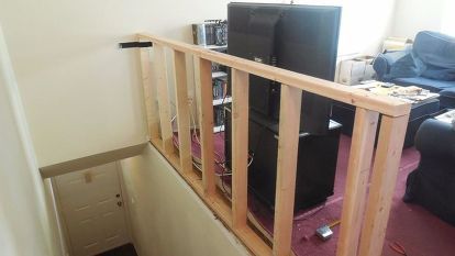 there are many speakers on the shelf in this living room that's under construction