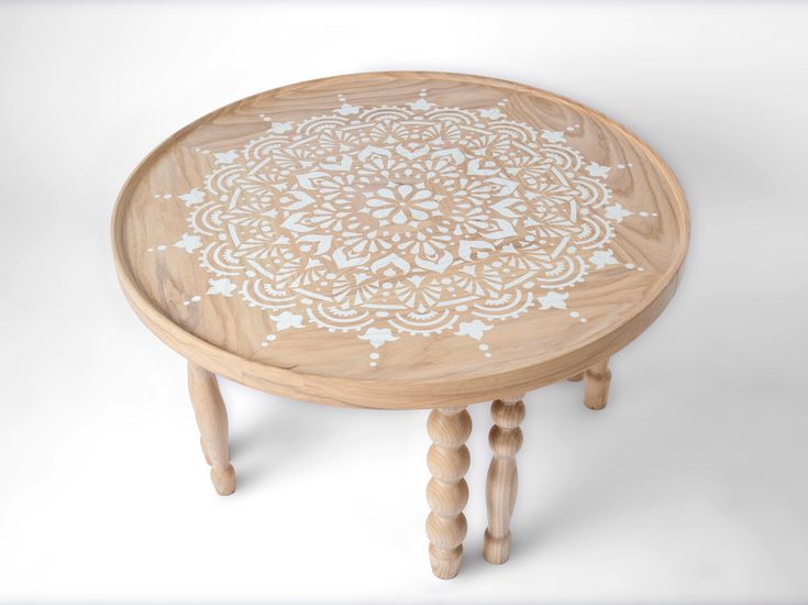 a small wooden table with white designs on it