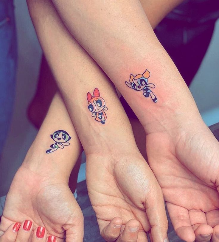 two people with matching tattoos on their arms holding each other's hands in the air