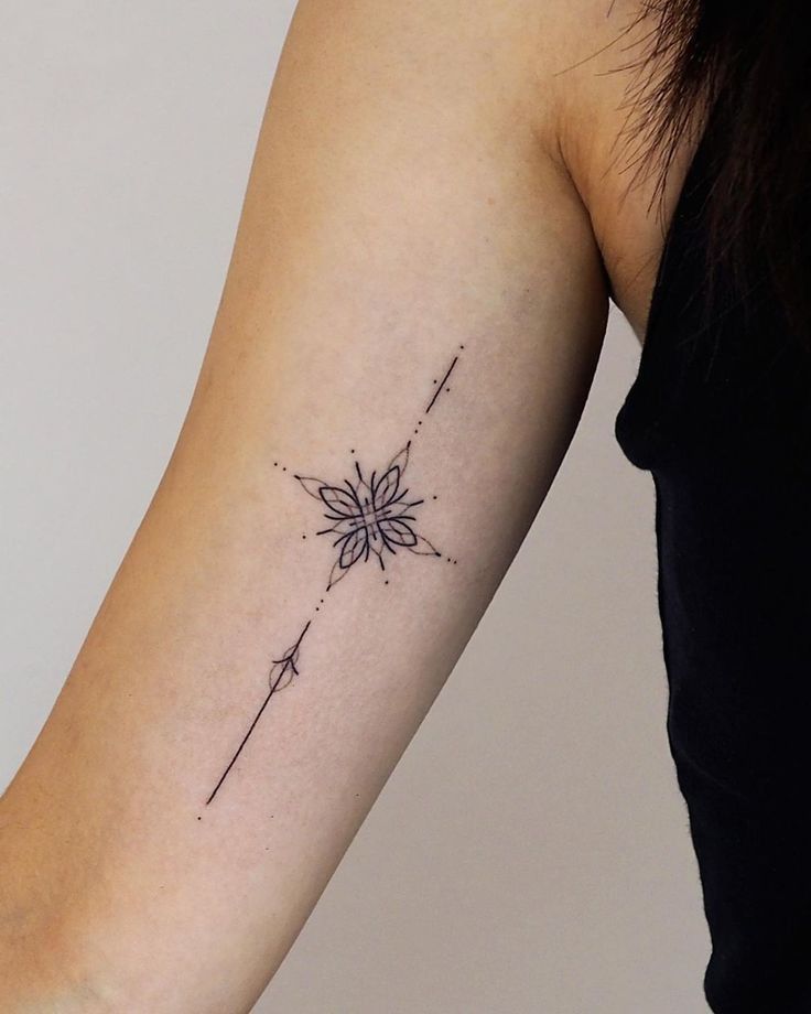 a woman's arm with a flower tattoo on the left side of her arm