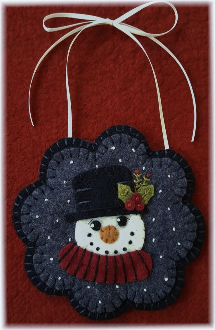 a snowman ornament hanging on a red wall