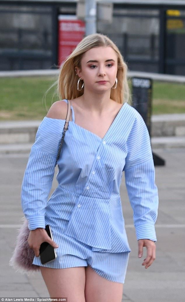 a woman walking down the street in short shorts