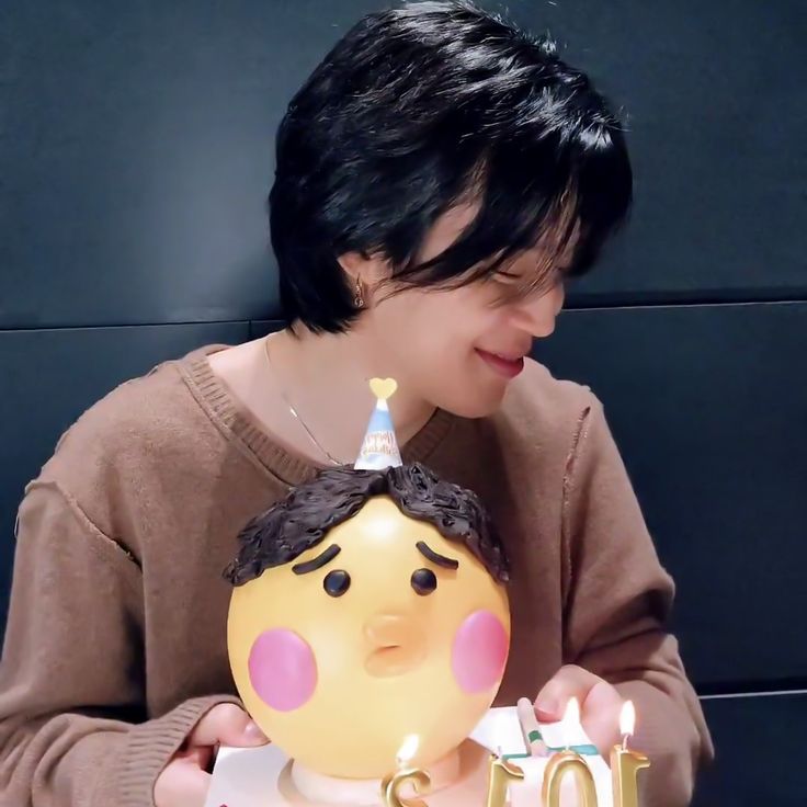 a person holding a birthday cake with candles