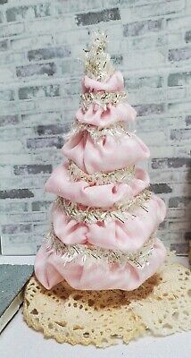 a pink christmas tree sitting on top of a doily