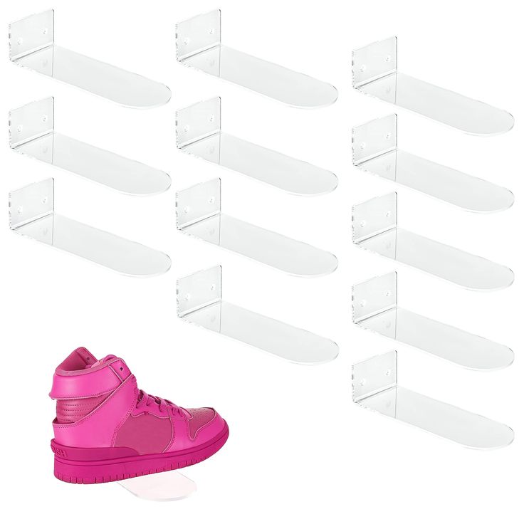 a pair of pink high top sneakers next to several clear plastic shoe holders on white background