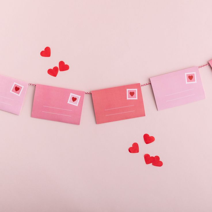 valentine's day card garland with hearts on pink background