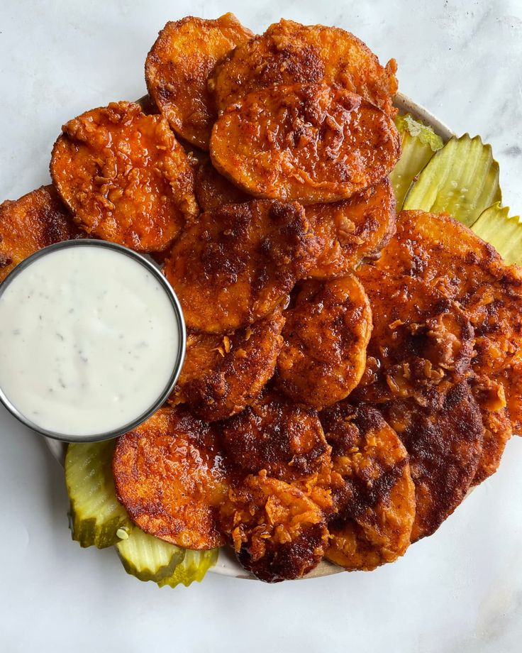 some fried food is on a plate with ranch dressing