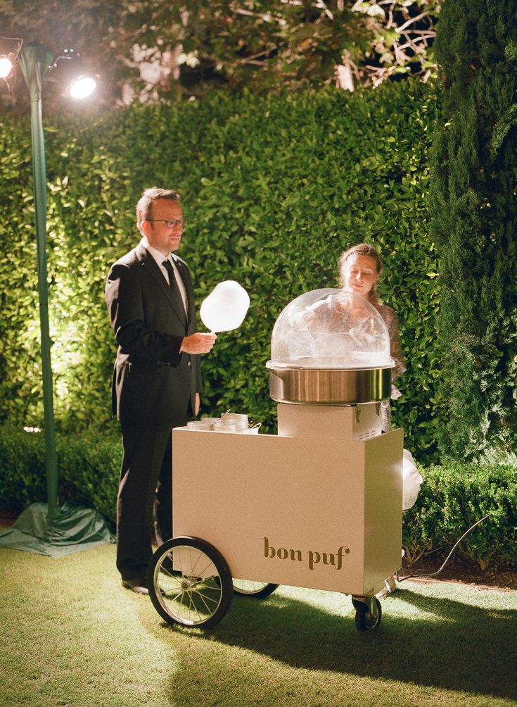 a man and woman standing in front of a cart