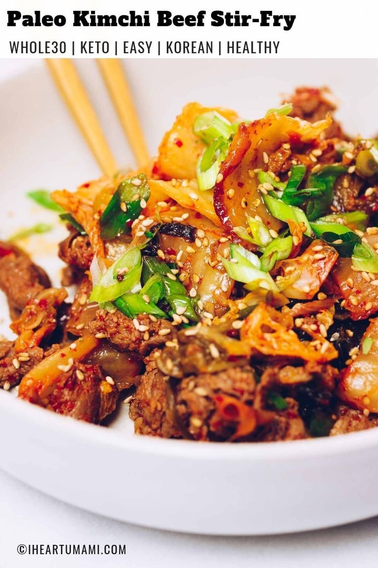 a white bowl filled with food and chopsticks