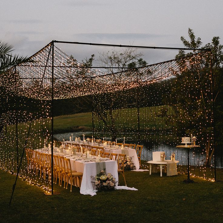 an outdoor wedding reception setup with string lights