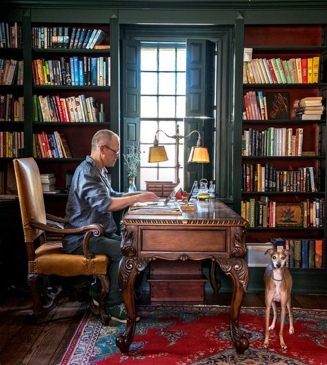 a man sitting at a desk in front of a dog