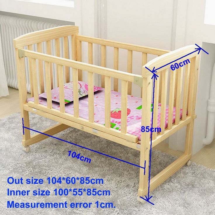 a wooden crib with measurements for the mattress