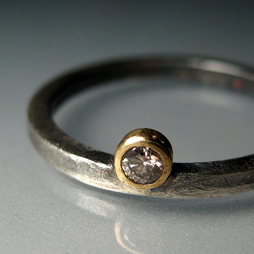 a close up of a ring with a diamond in it