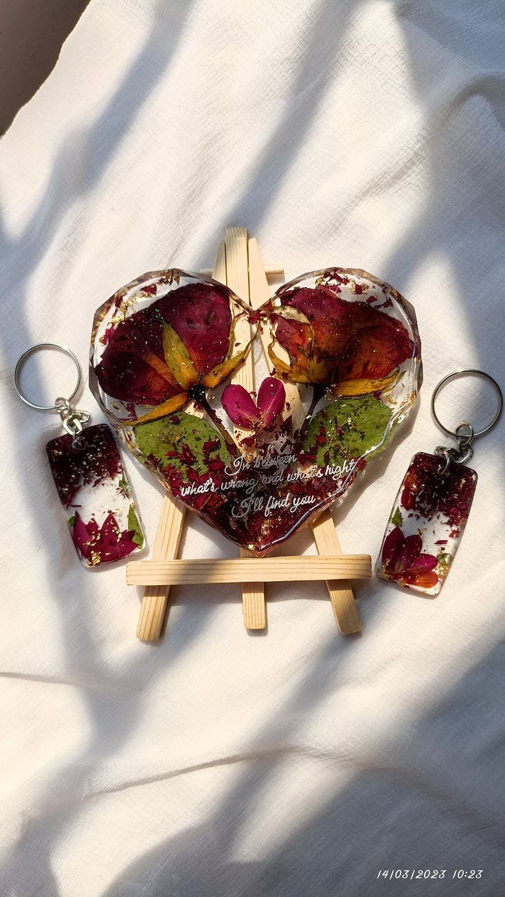 a heart shaped dish with four pieces of food in it sitting on a wooden stand