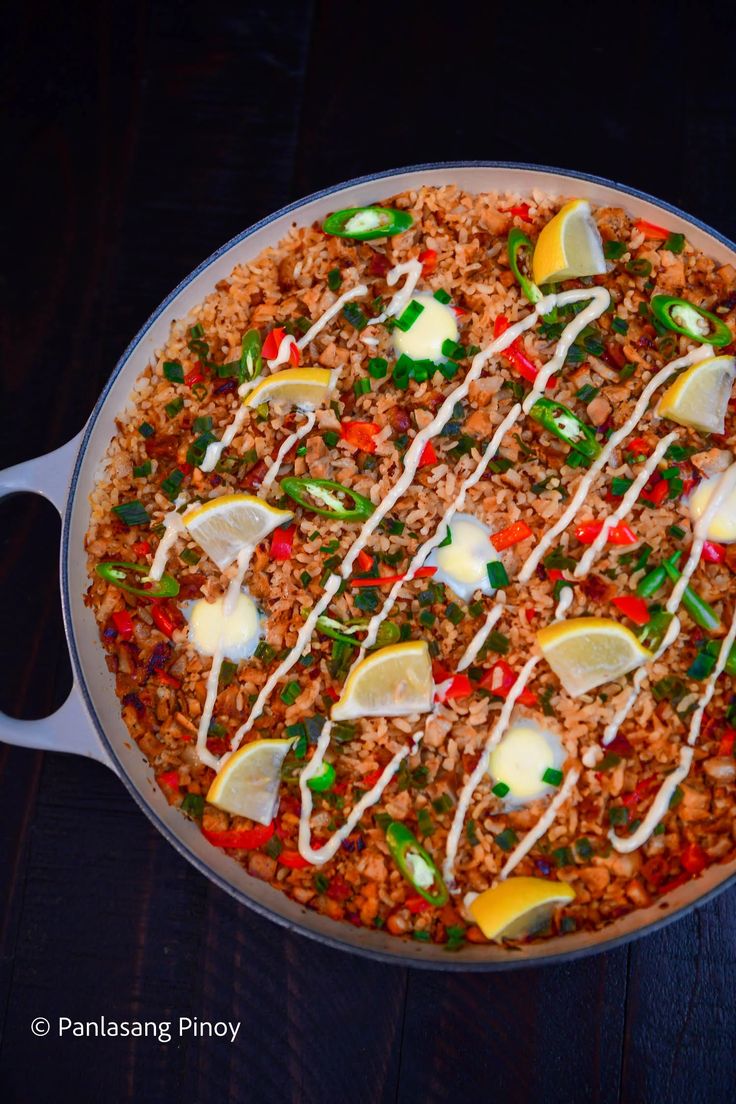 a pan filled with rice and vegetables on top of a wooden table